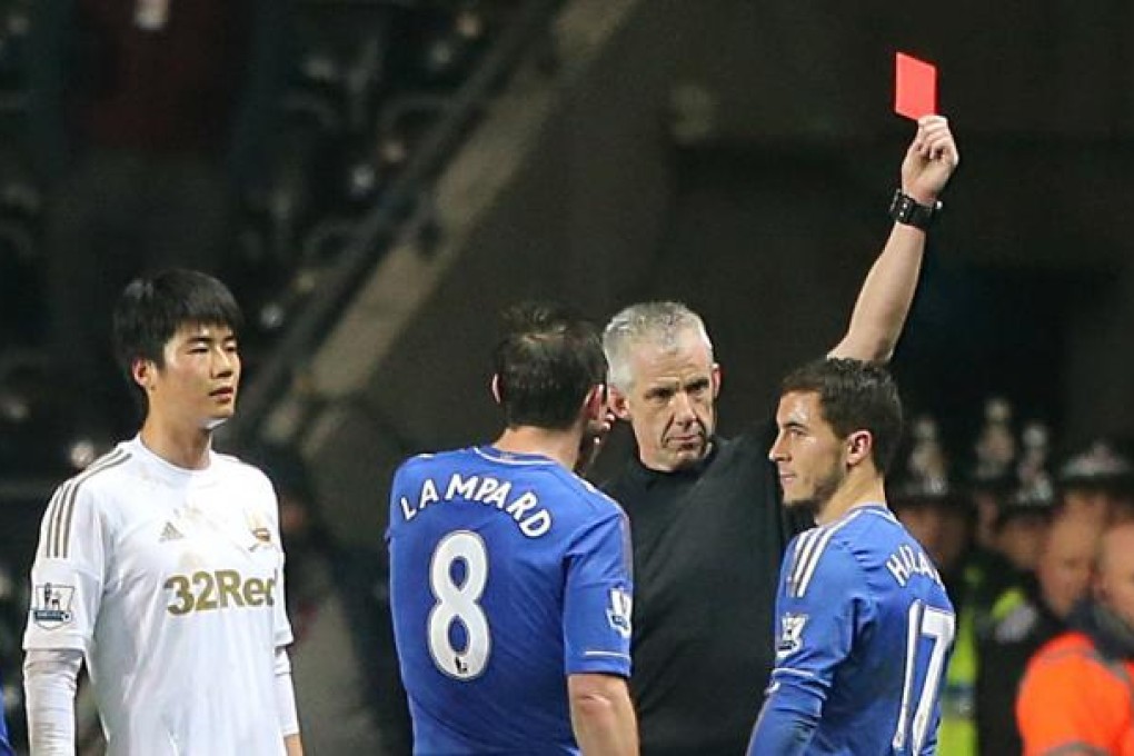 Chelsea's Eden Hazard (right) receives a red card from referee Chris Foy for violent conduct during an English League Cup match. Photo: AP