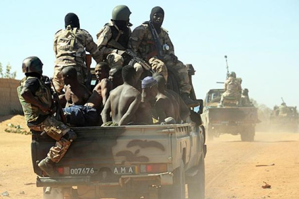Malian soldiers transport a dozen suspected Islamist rebels on Friday after arresting them north of Gao. Photo: AFP