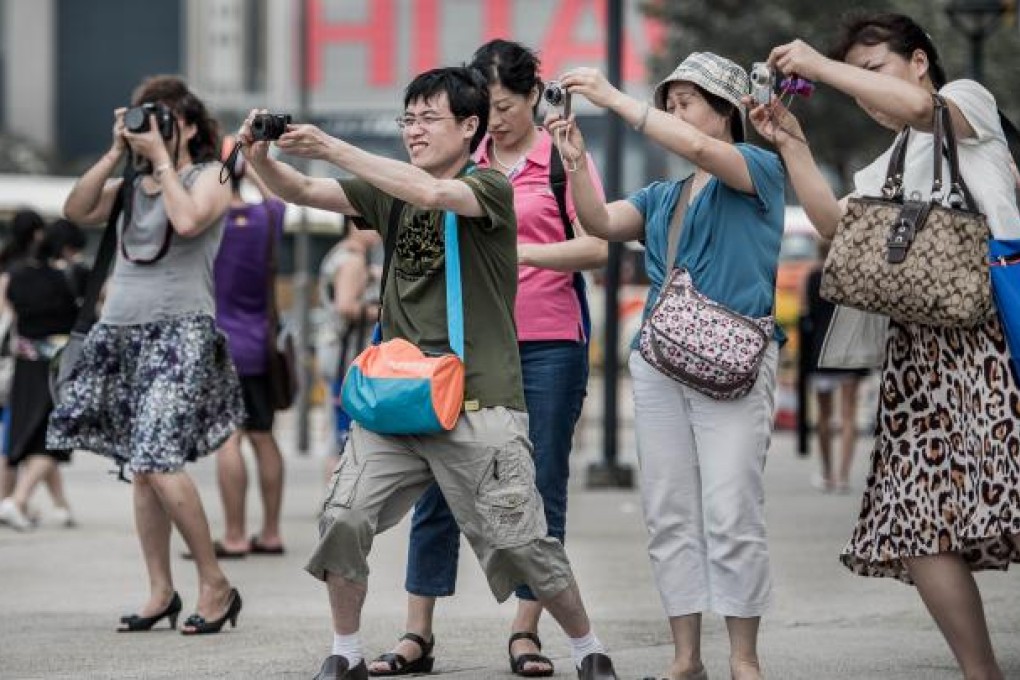 Tourists from mainland China take pictures during a visit to Hong Kong. Photo: AFP
