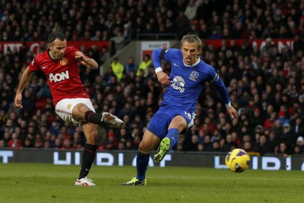 Ryan Giggs scores past Everton's Phil Neville, ensuring he has scored in every one of the past 23 Premier League seasons. Photo: Reuters