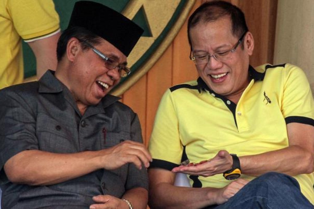 Aquino (right) jokes with MILF chief Murad Ebrahim.Photo: AFP