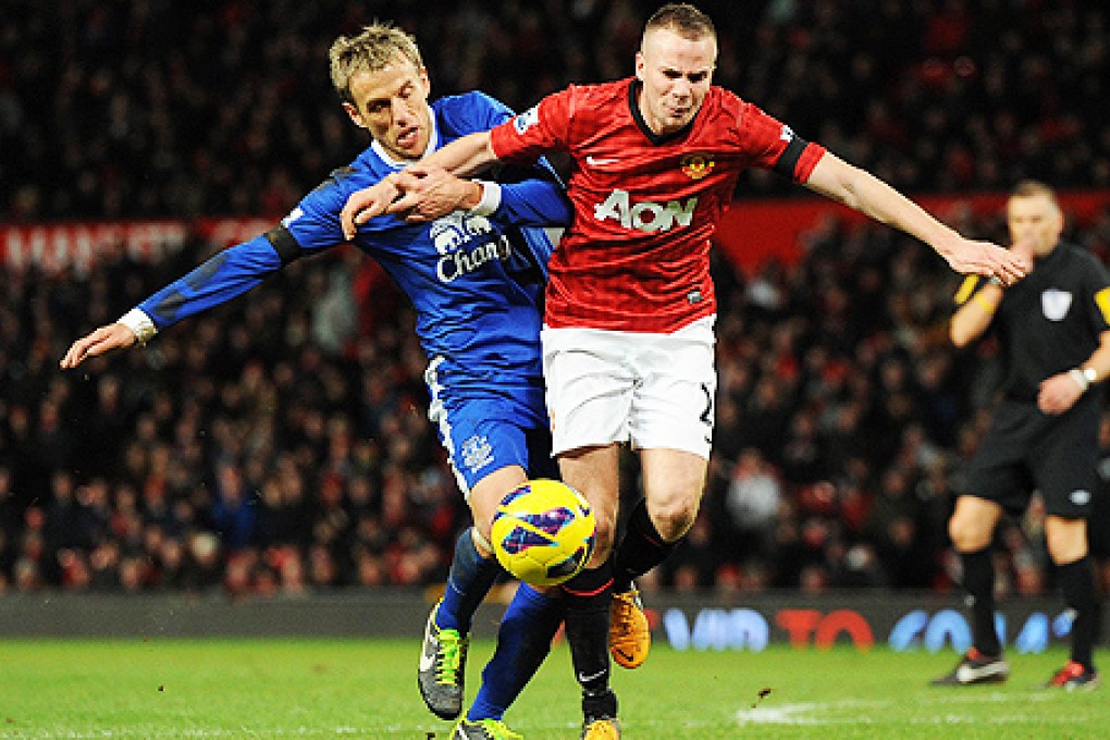 Everton's Phil Neville (left) vies for the ball with Tom Cleverley. Photo: EPA