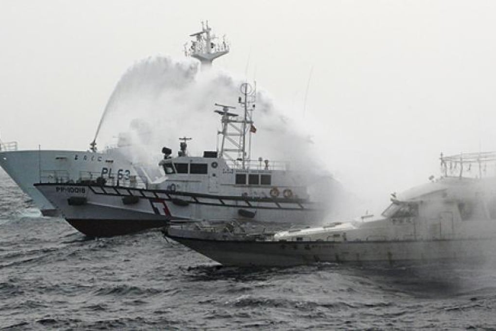 A Japan Coast Guard patrol ship (left) shoots water at a fishing boat carrying Taiwanese activists near the Diaoyu Islands last month. Photo: Reuters