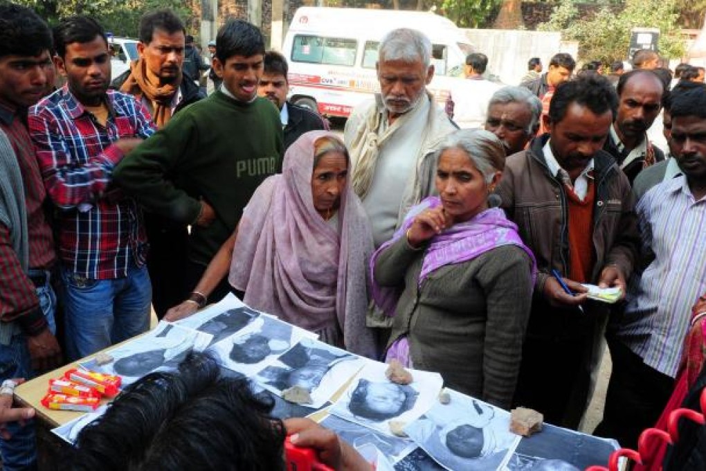 Relatives view photos of the dead at a morgue in Allahabad. Photo: AFP