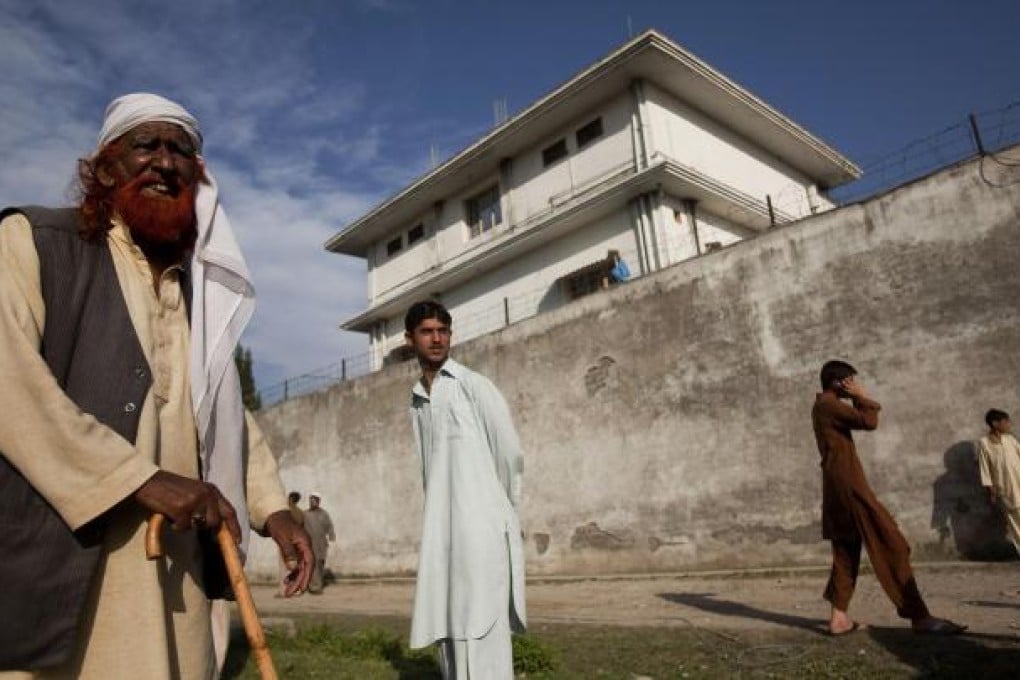 Curious locals gather outside the Abbottabad compound after the commando raid that killed Osama bin Laden. Photo: NYT