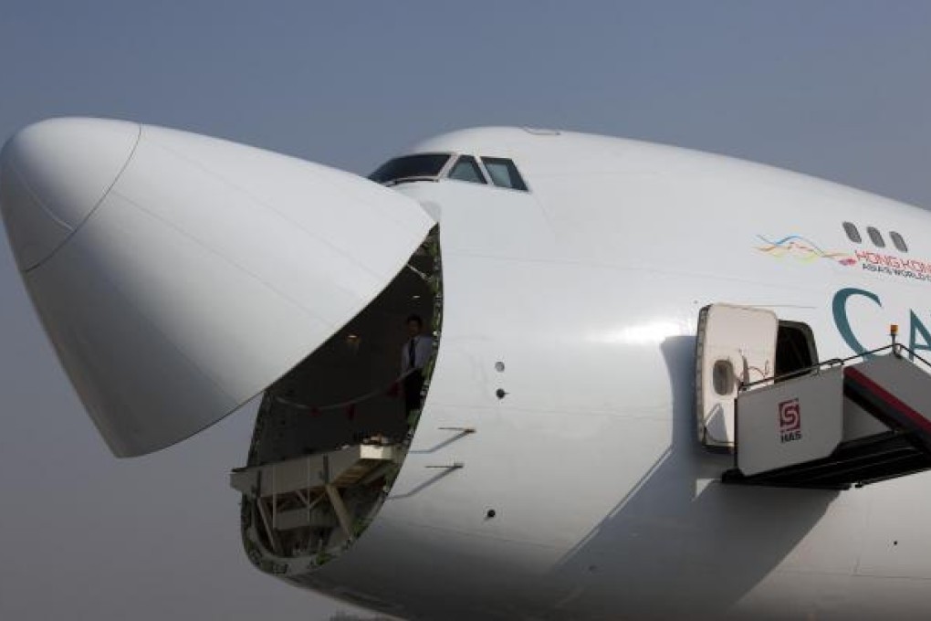 A Cathay Pacific Boeing 747-8 air cargo carrier sits on the tarmac with its nose door open at Chek Lap Kok airport. Photo: Bloomberg