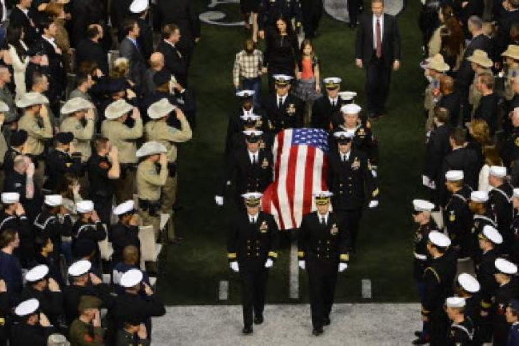 Taya Kyle and her son and daughter exit the memorial behind husband Chris Kyle's coffin after a service for the Navy Seal sniper at Arlington in Texas. Photo: EPA