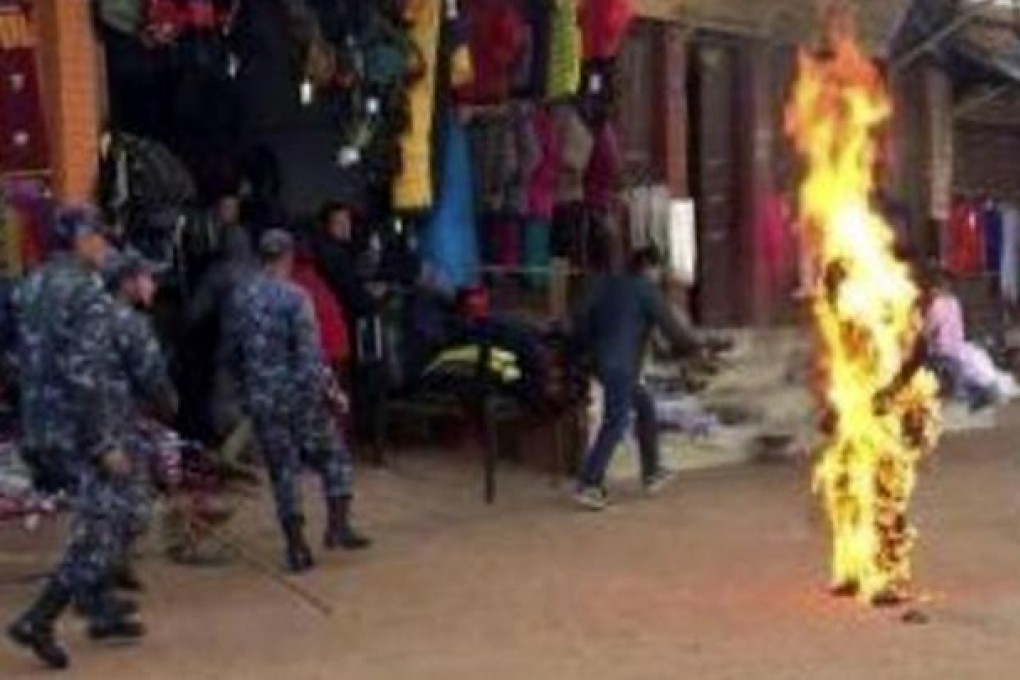 Nepalese policemen surround the burning monk. Photo: AP