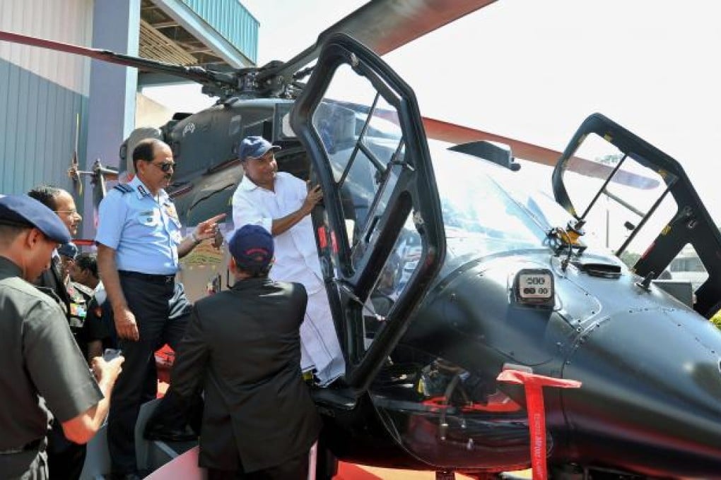 Indian defence minister AK Antony (R) gets into the cockpit of a HAL Rudra helicopter while Chief of Air Staff Air Chief Marshal NAK Browne (C, in blue) looks on during last week’s aviation trade show in India. Photo: AFP