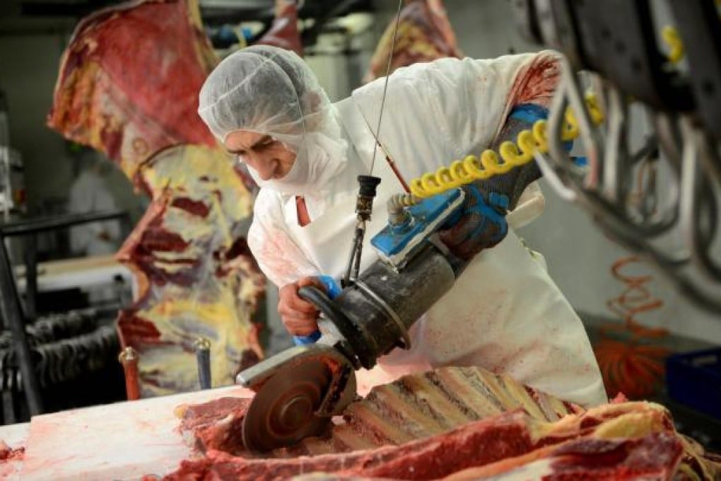 A worker slices a carcass at Doly-Com abattoir. Orders for horsemeat, which make up 5 per cent of exports, have been suspended.Photo: AFP
