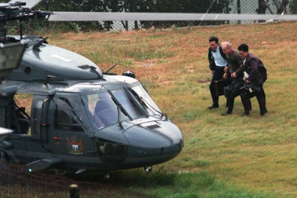 Warwick Reid is escorted to a Black Hawk helicopter by ICAC officers in November 1994 after serving his jail term at Siu Lam Psychiatric Centre. Photo: SCMP Pictures