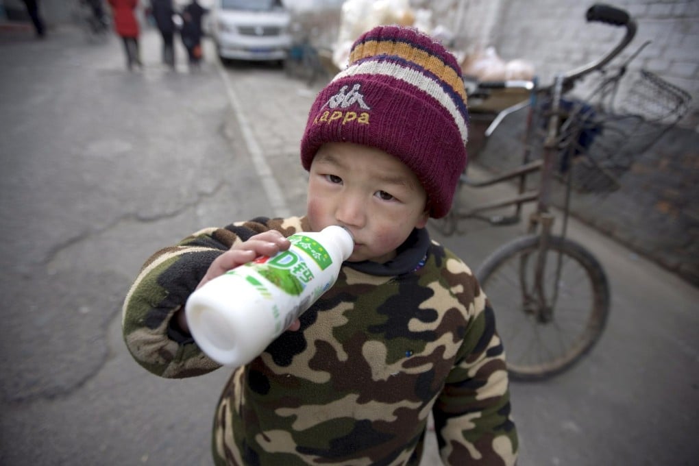 A toddler in drinks a milk drink on a Beijing street, January 13, 2009, just months after a tainted milk scandal rocked the country. Photo: EPA
