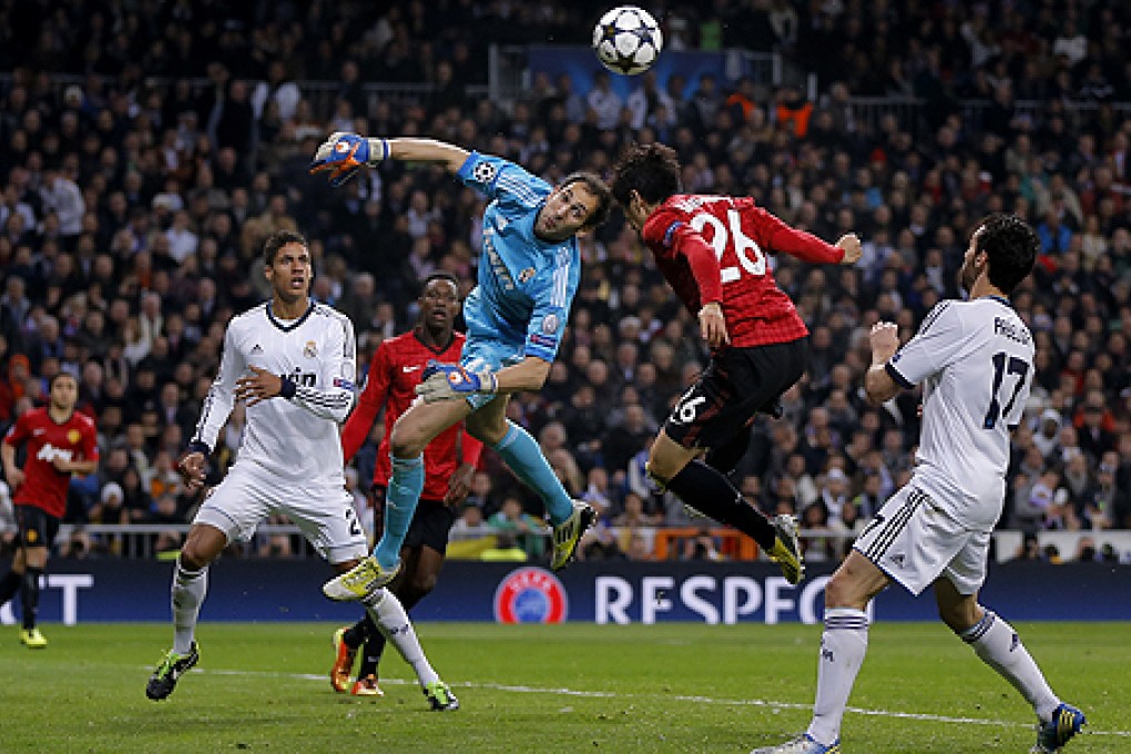 Real Madrid's goalkeeper Diego Lopez (centre left) duels for the ball with Manchester United's Shinji Kagawa. Photo: AP