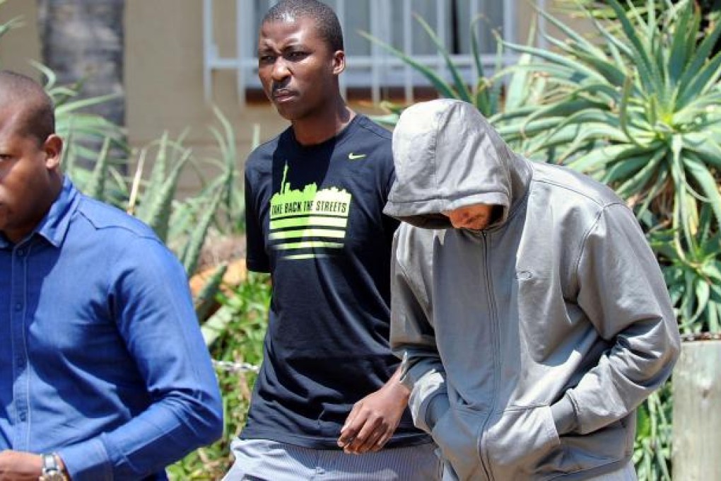 Pistorius keeps his head down in a hoodie as he leaves the Boschkop police station, Pretoria, before appearing in court. Photo: AP