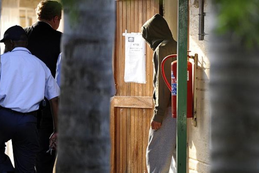 Olympic athlete Oscar Pistorius heads to the holding cells at the Boschkop police station, east of Pretoria, South Africa. Photo: AP