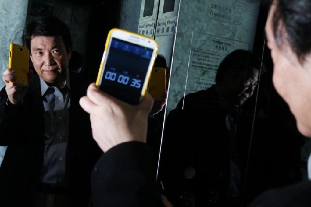 Schindler Lifts technical director Wong Ming-wan checks the time it takes for a lift at the ICC to travel from the third floor to the 48th floor - 35 seconds. Photo: Edward Wong