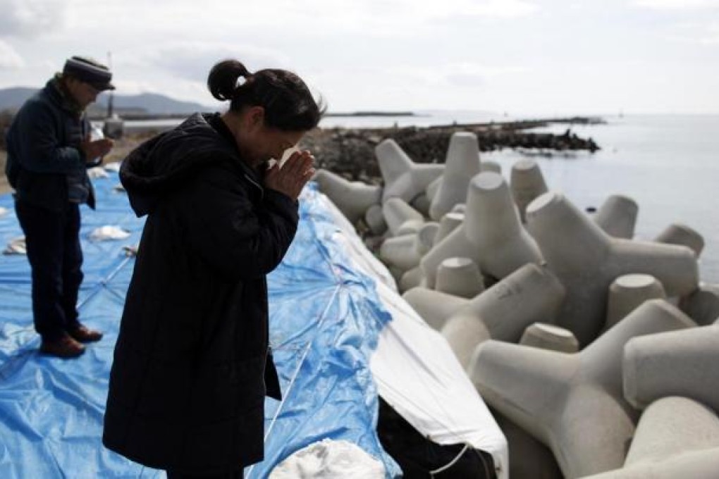 People pray towards the sea to mourn their friends, who died in the March 11, 2011 earthquake and tsunami, in Ishinomaki. Photo: Reuters