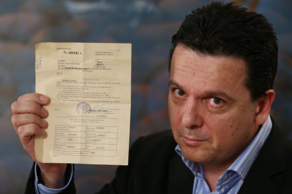 Australian Independent Senator Nick Xenophon holds up his deportation notice during a press conference after arriving back in Australia on Sunday. Photo: EPA
