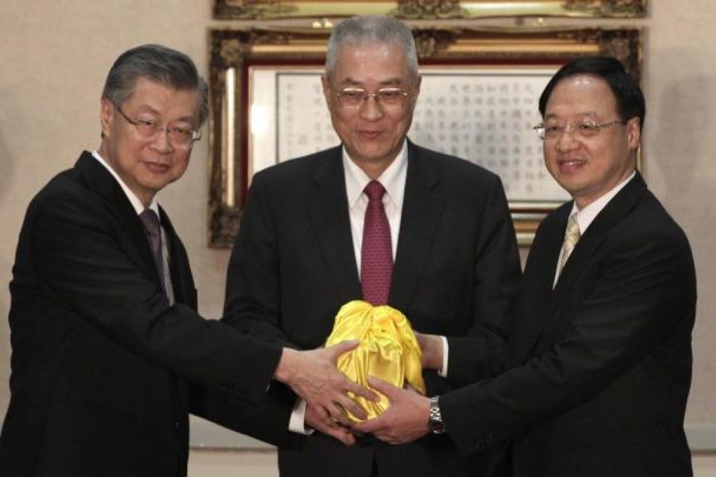 Jiang Yi-huah (right) receives the official seal from Sean Chen (left) and Wu Den-yih. Photo: Reuters