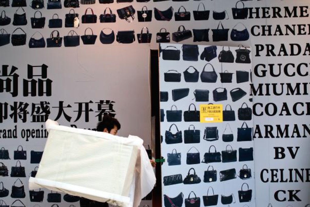 A worker furnishes a new luxury goods re-seller in Beijing. Photo: AP
