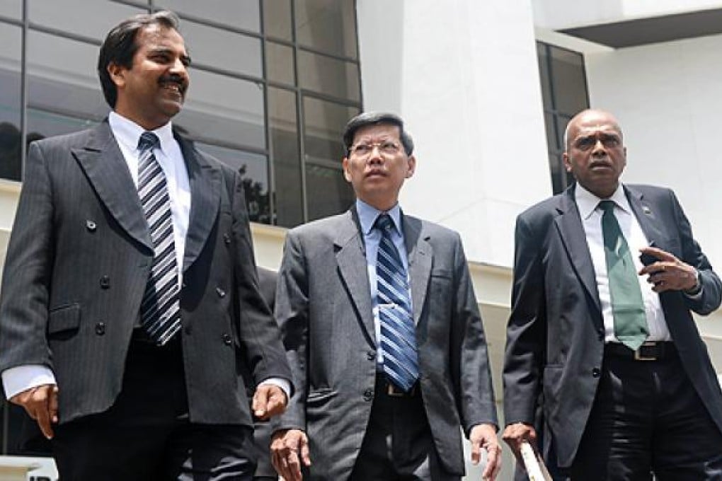 Peter Lim (centre), Singapore's former civil defence chief, leaves the subordinate court for a lunch break with his two lawyers in Singapore on Monday. Photo: AFP