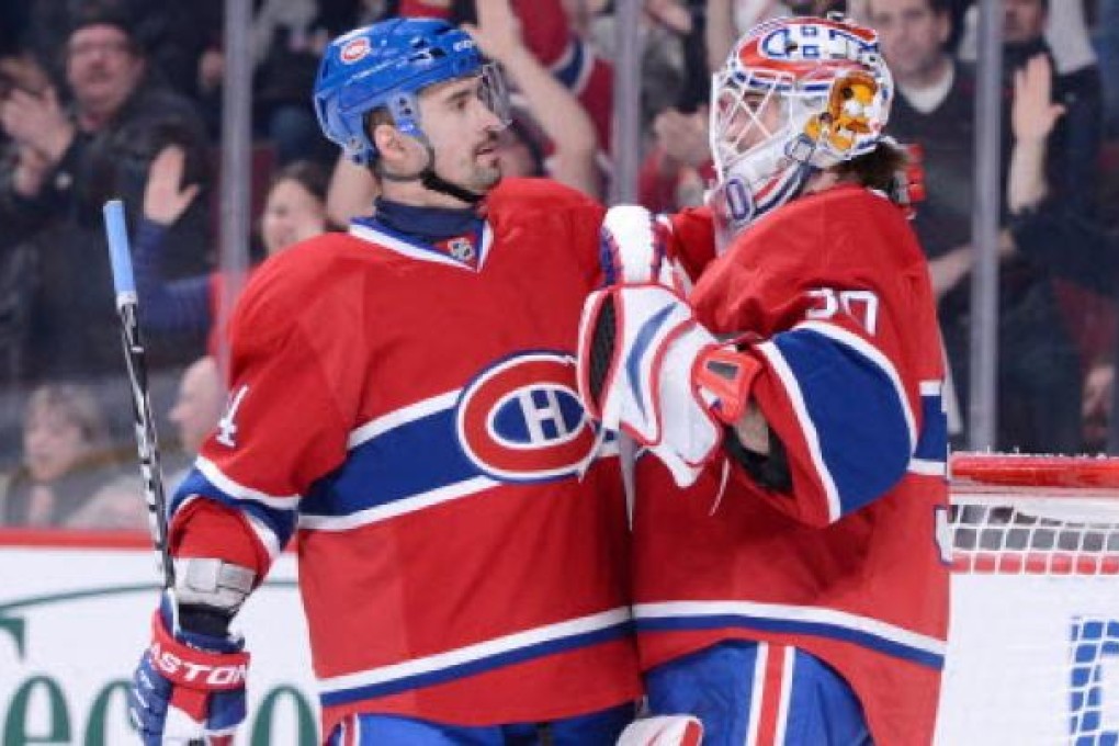 Tomas Plekanec #14 and Peter Budaj #30 of the Montreal Canadiens celebrate after defeating the Carolina Hurricanes in Montreal. Photo: AFP