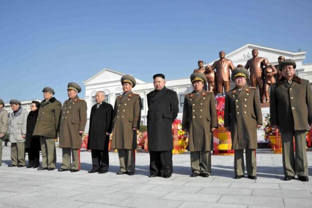 Kim Jong-un (4th from right) and senior officials posing before the statues of late leaders Kim Il-Sung and Kim Jong-Il in Pyongyang. Photo: AFP