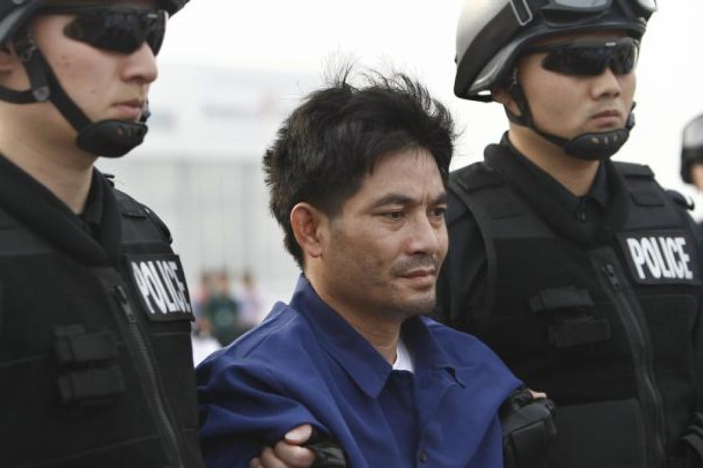 Mekong drug lord Naw Kham is restrained by two Chinese police officers. Photo: Xinhua