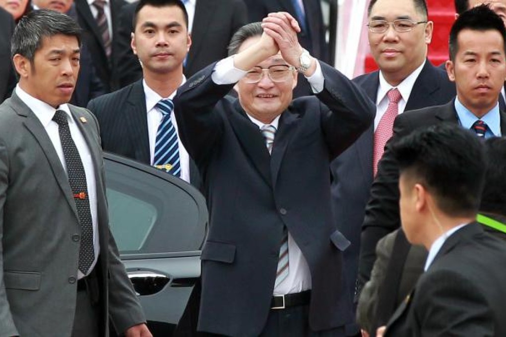 Wu Bangguo (centre) arrives in the city, flanked by Macau Chief Executive Fernando Chui Sai-on (in red tie). Photo: SCMP