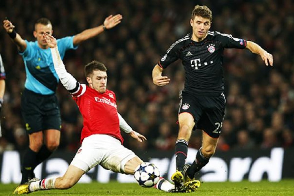 Aaron Ramsey (left) of Arsenal goes up against Thomas Muller of Bayern Munich on Tuesday. Photo: Xinhua