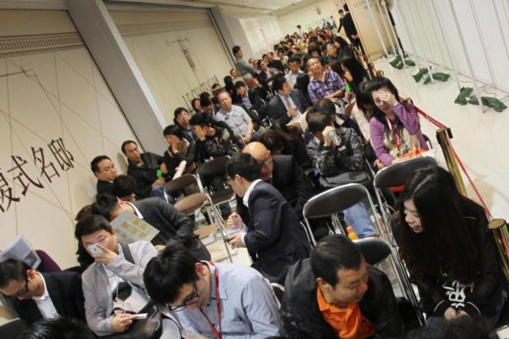 Property agents and buyers cram into the sales office for Cheung Kong's Apex Horizon hotel in Kwai Chung yesterday. Photo: David Wong