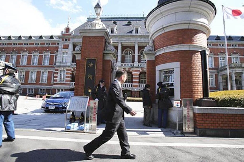A man walks in front of the Justice Ministry in Tokyo. The ministry said Japan executed three inmates convicted of murder early on Thursday. Photo: AP