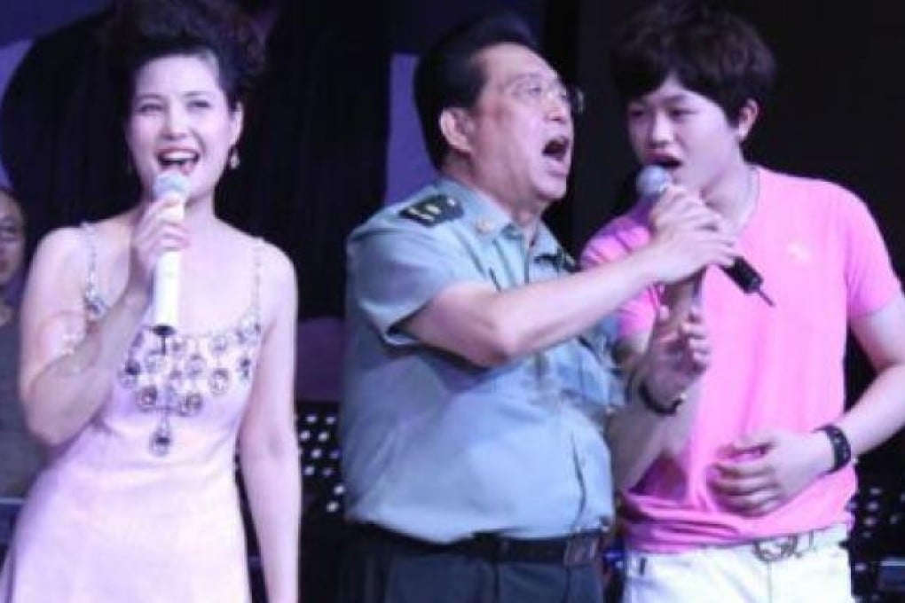 PLA Major General Li Shuangjiang, centre, with his wife Meng Ge. left, and son Li Tianyi sing on stage on this undated handout photo. SCMP Pictures