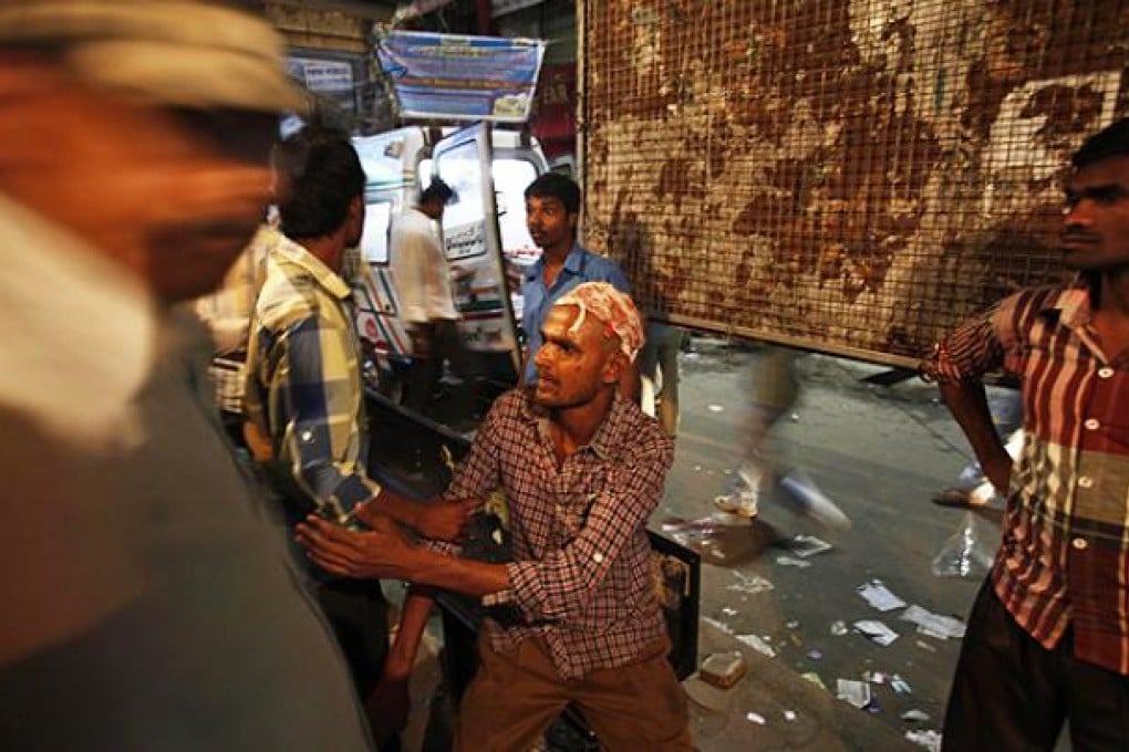 An injured person is helped near the site of a bomb blast in Hyderabad. Photo: AP