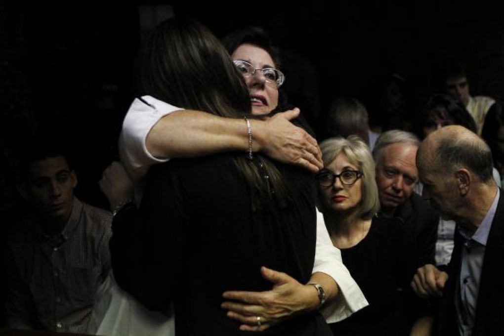 Relatives of Oscar Pistorius hug each other in court in Pretoria. Photo: Reuters