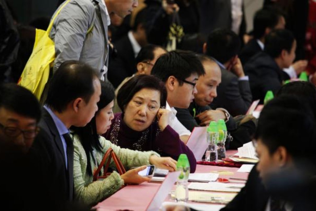 Buyers make deals to buy rooms in the Apex Horizon Hotel. Photo: Reuters