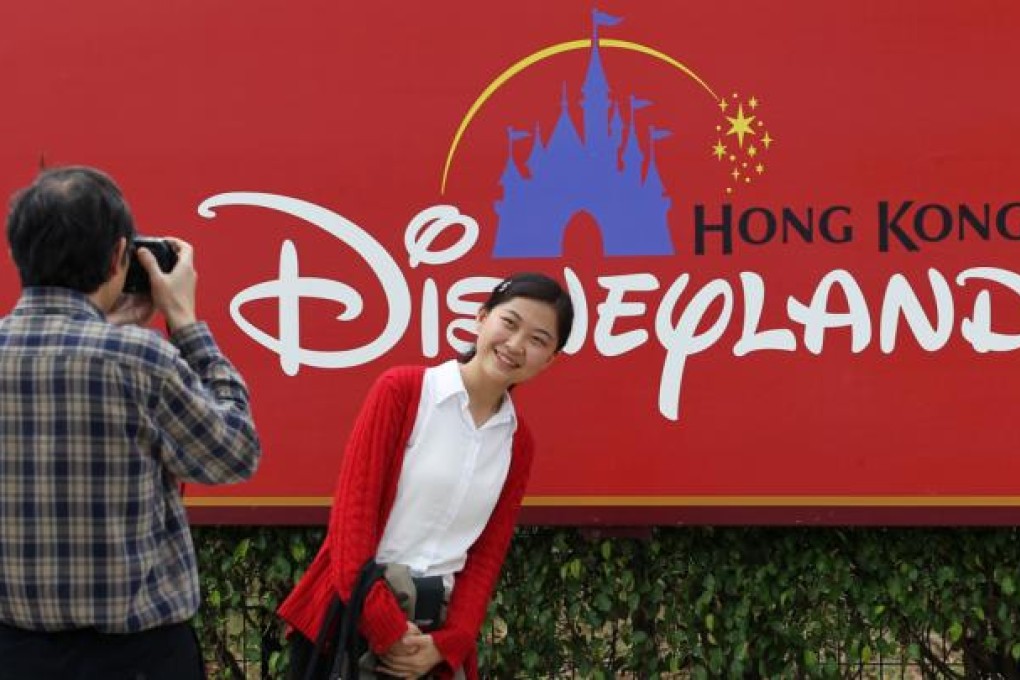 A mainland tourist couple enjoy a fun day out at Hong Kong Disneyland on Lantau Island. Photo: Nora Tam