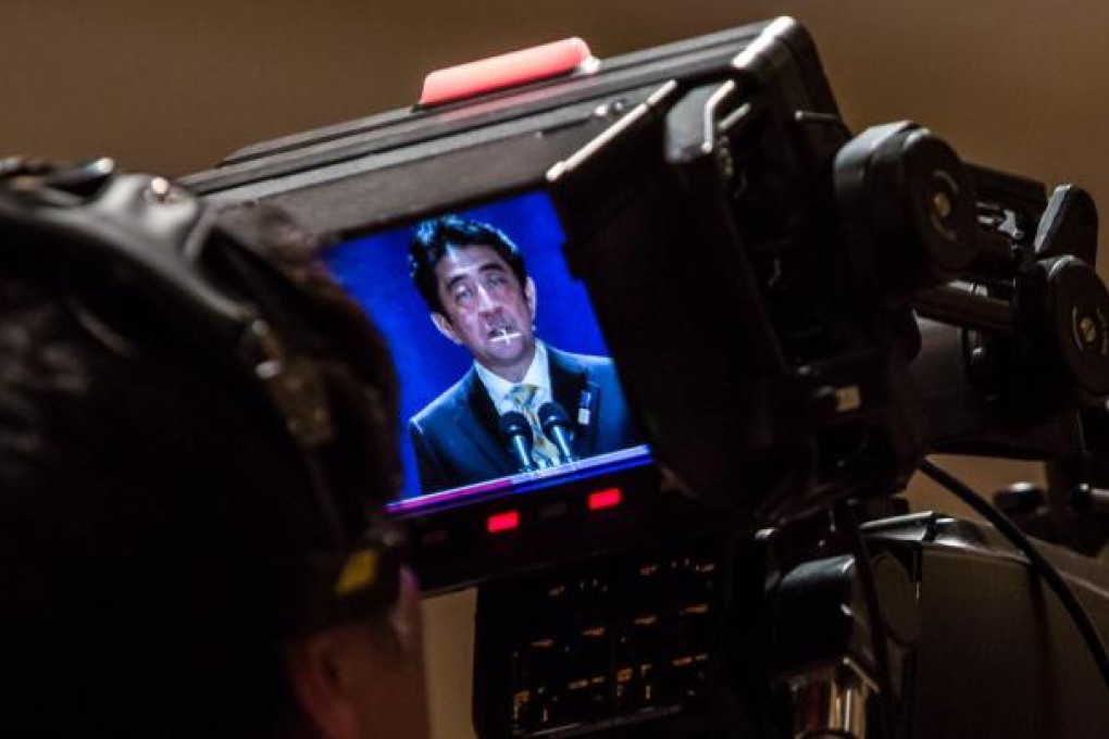 Shinzo Abe seen on a television camera monitor. Photo: AFP