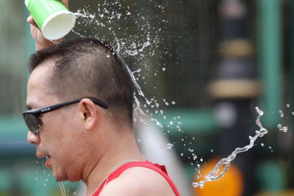 A competitor takes some time to cool off during the 10-kilometer race, which attracted a record entry of 38,000 people. Photo: Sam Tsang