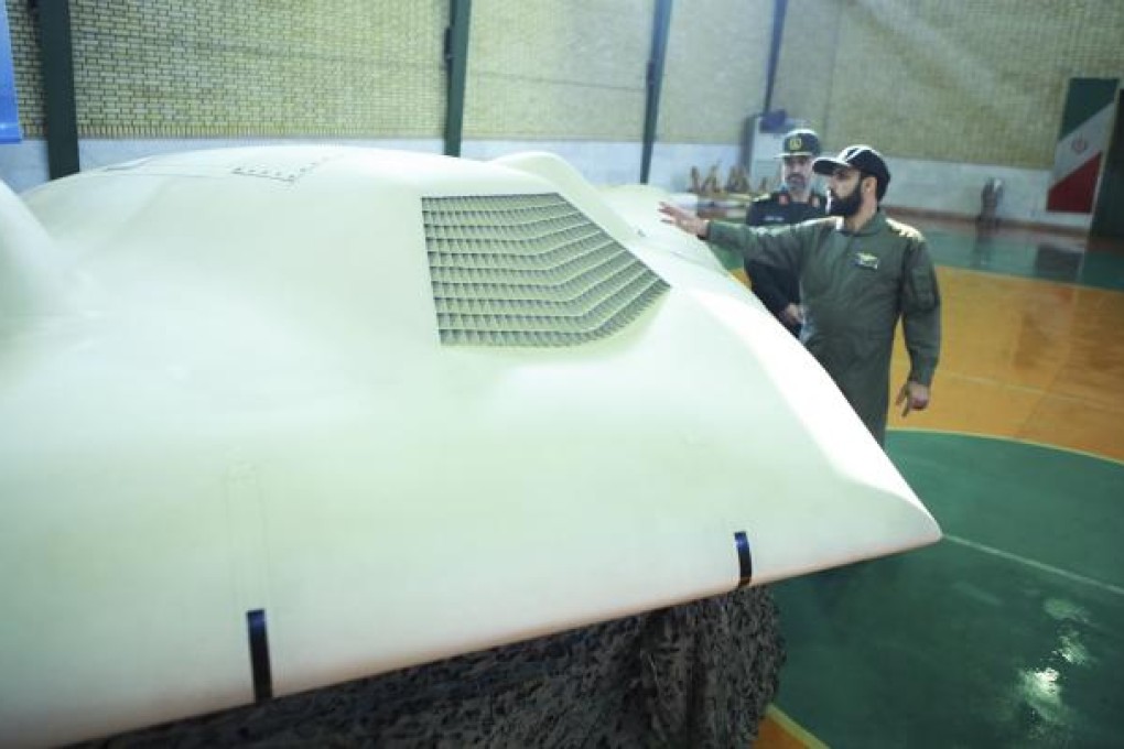 A revolutionary guard pointing to a US RQ-170 drone captured by Iran, in December 2011. Photo: Reuters