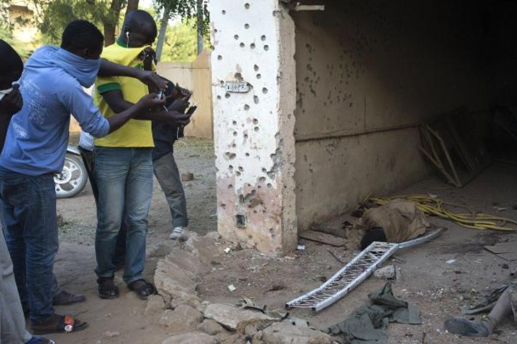 Men take photos of Islamist fighters' bodies. Photo: AFP