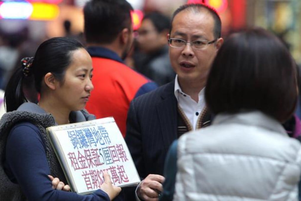 A property agent (left) speaking to prospective buyers of commercial shops in Great George Street, Causeway Bay. Photo: Dickson Lee