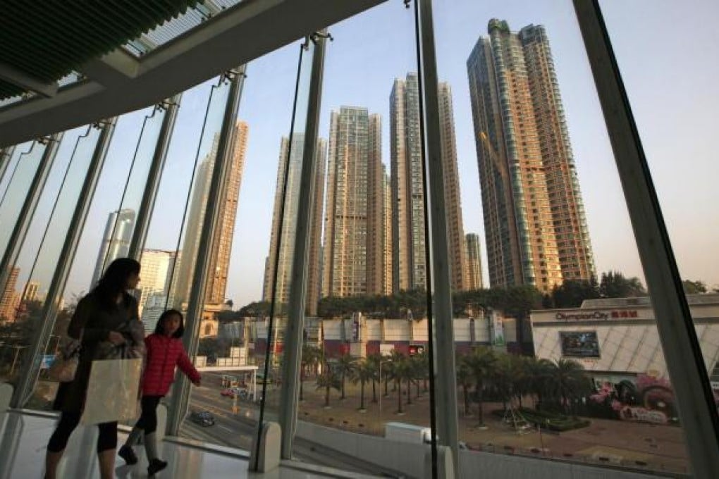 Pedestrians walk on a footbridge in front of a row of high-rise buildings under construction. Photo: AP
