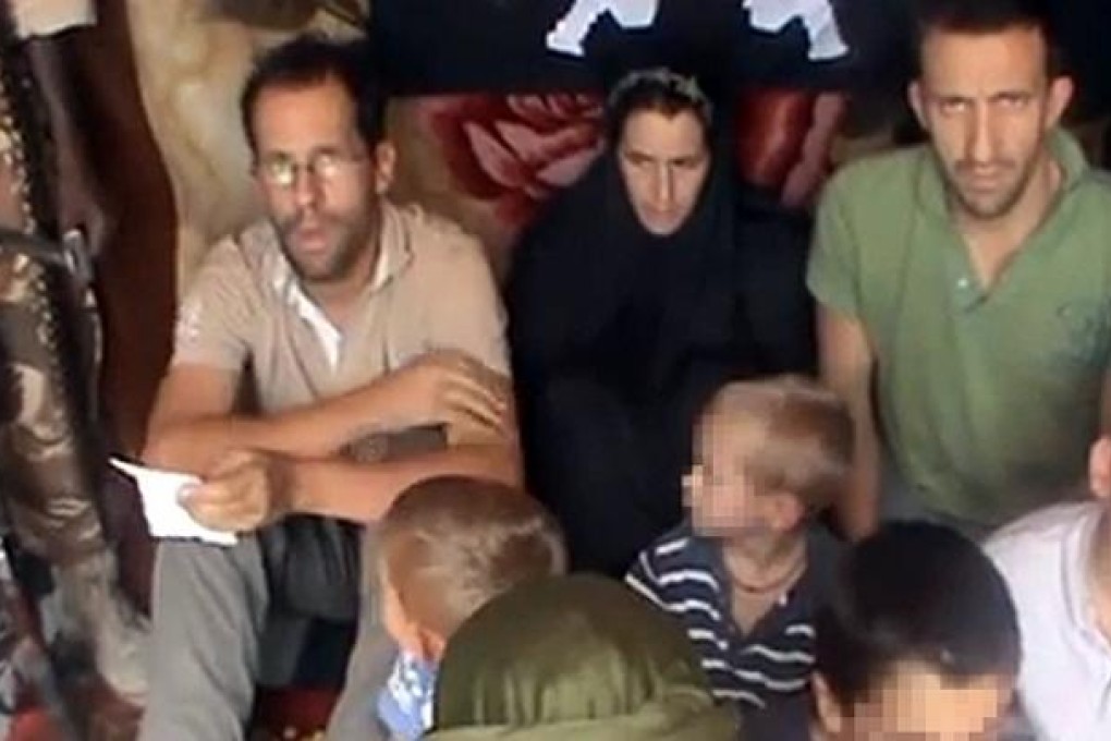 Tanguy Moulin-Fournier (left) sitting next to his wife, Albane, his brother Cyril, and their four children flanked by an armed man in an undisclosed place. Photo: AFP