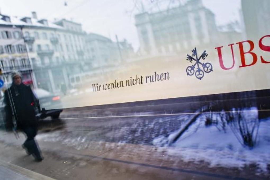 Logo of Swiss bank UBS and a slogan reading 'we will not rest' is seen in a window of a building at Paradeplatz square in Zurich. Photo: Reuters