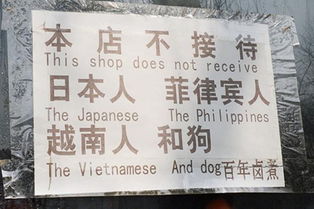 A sign at a Beijing restaurant barring citizens of nations involved in maritime disputes with China -- along with dogs. Photo: AFP