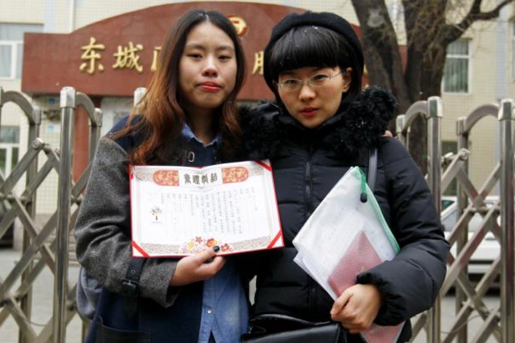 Elsie Liao (left) and Ma Yu Yu show a fake marriage certificate outside the marriage registry office. Photo: EPA