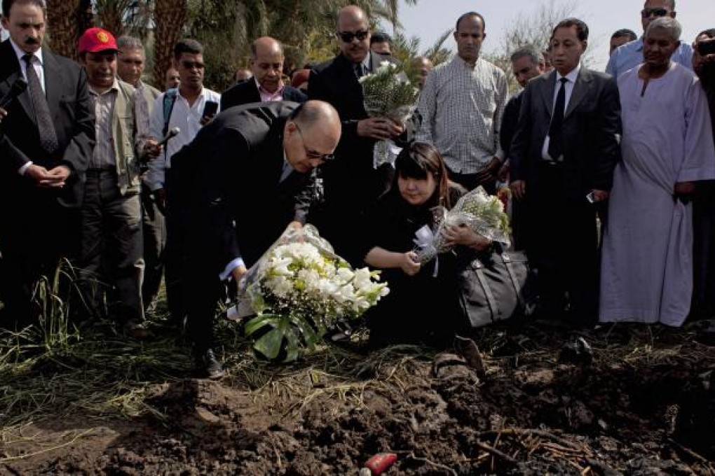 Luxor’s governor Ezzat Saad and Japanese travel agent Okumura Hatsuko pay their respects to the dead. Photo: AP