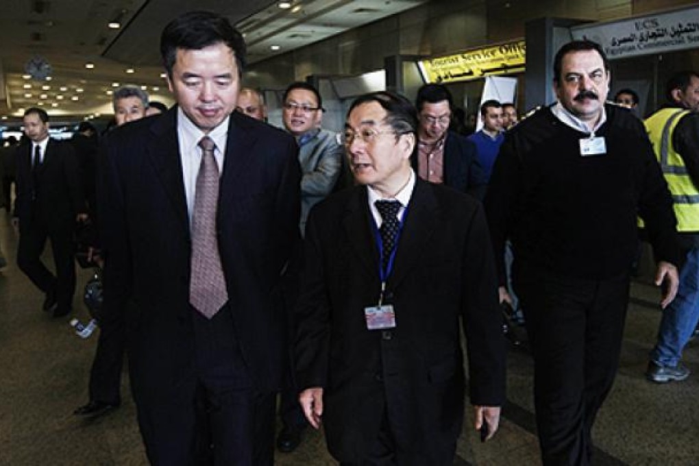 Chinese Ambassador to Egypt Song Aiguo (centre) is escorted by an unidentified immigration official from Hong Kong (left) as they arrive at Cairo International Airport on Wednesday. Photo: AFP