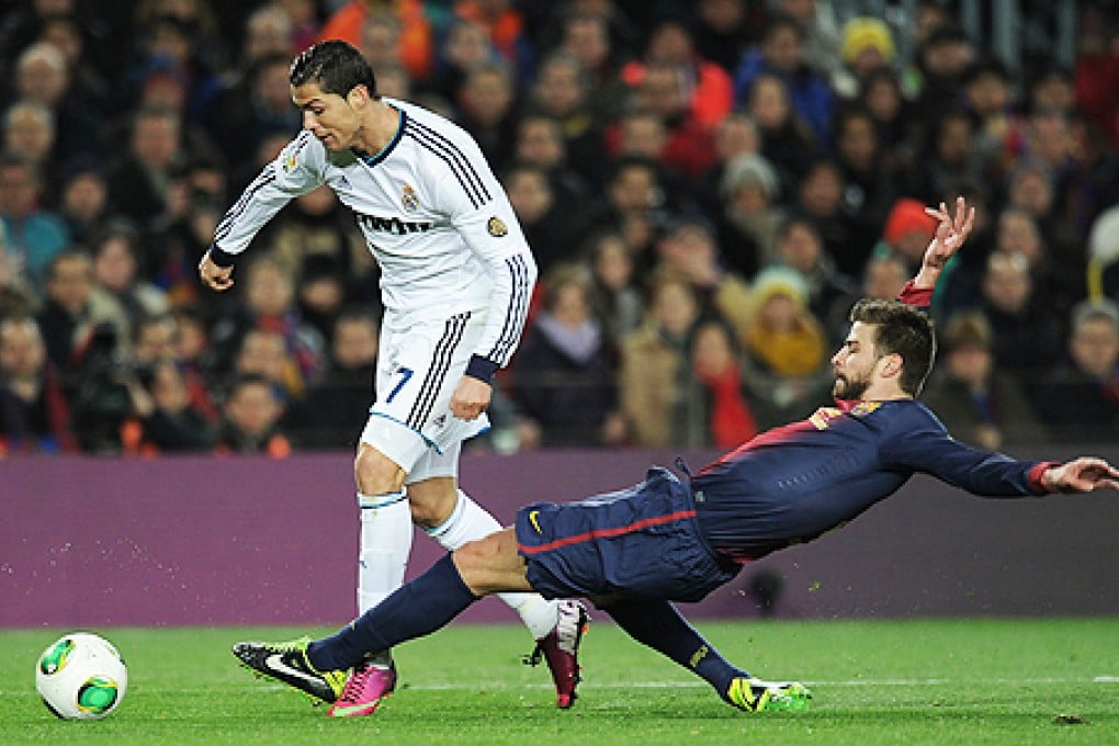 Barcelona's Gerard Pique (right) vies with Real Madrid's Cristiano Ronaldo on Tuesday. Photo: AFP